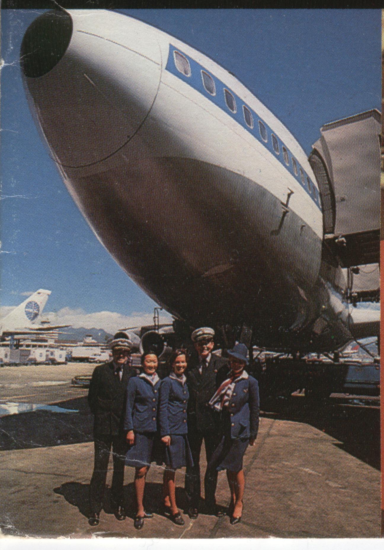 1977 Some Pan Am crew members pose by the nose of a 747 at the gate in San Francisco with the mountains in the background.
